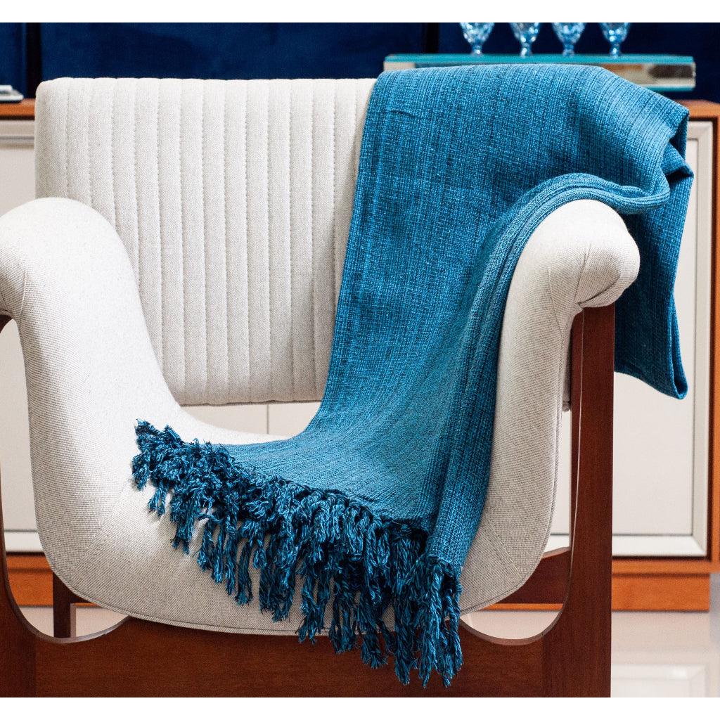 Manta para sofá de luxo de cor azul sobre uma poltrona de luxo